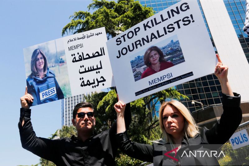 Pengunjuk rasa pro Palestina membawa spanduk dengan gambar jurnalis Al Jazeera Shireen Abu Akleh, yang tewas dalam serbuan Israel di Jenin, selama aksi protes di depan konsulate Israel, di Istambul, Turki, Kamis (12/5/2022) (ANT)