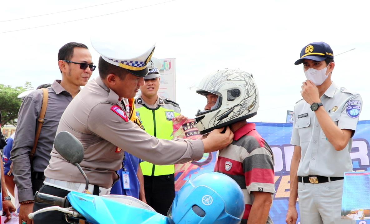 Polisi Bagikan Puluhan Helm dan Jaket  Untuk Pengendara di Tugu Gajah Pringsewu