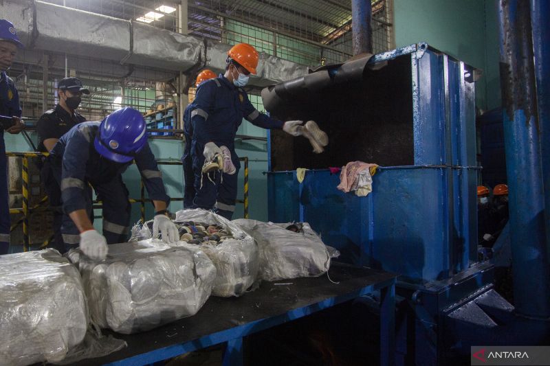 Pekerja memasukkan sejumlah sepatu bekas impor ilegal kedalam mesin penghancur untuk dimusnahkan di Batam, Kepulauan Riau, Senin (3/4/2023)