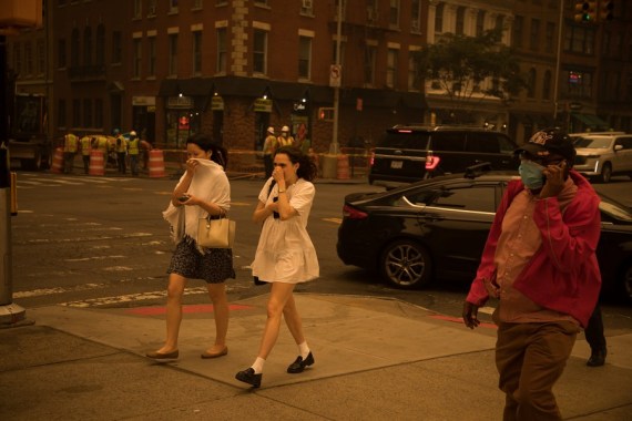 Para pejalan kaki yang menutupi wajahnya melintas di sebuah jalan di New York, Amerika Serikat, pada 7 Juni 2023. (Xinhua)